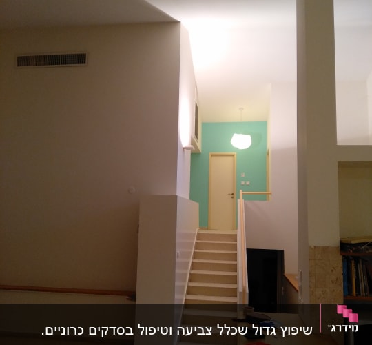 דלי צבע ומברשת על שולחן עץ